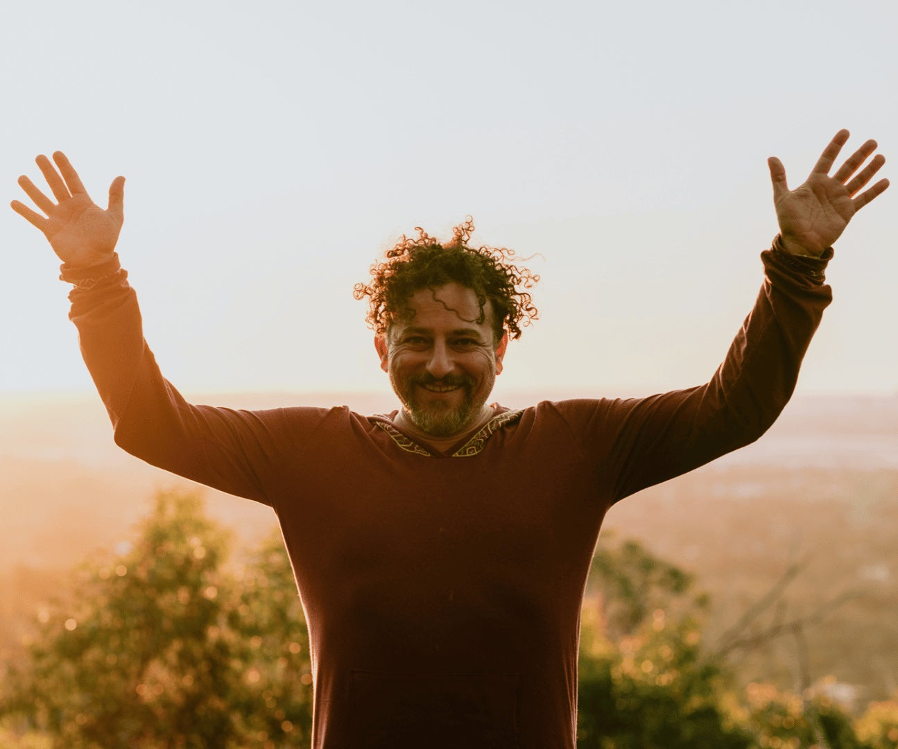 David Wolfe with his arms raised at sunrise